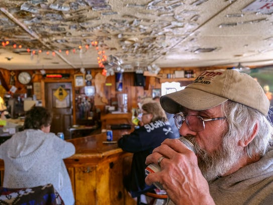 Mike Williams, 62, of Sugar Island enjoys a beer while