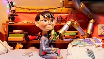 In this Wednesday, photo, young explorer Alex uses a telescope to look at the stars in a Macy's department store window in New York. Spectators can follow Alex as he soars from planet to planet before returning to Earth.