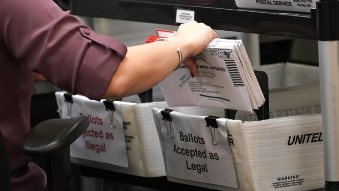 An election worker sorts vote-by-mail ballots at the Miami-Dade County Board of Elections in Doral, Fla., on Oct. 26.