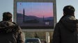 People watch news footage of a missile launch on a