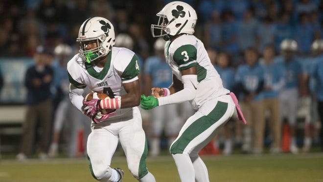 Camden Catholic quarterback Rob McCoy Jr. hands off to tailback Marcus Hillman in Friday night's game, a 25-21 win over Shawnee.