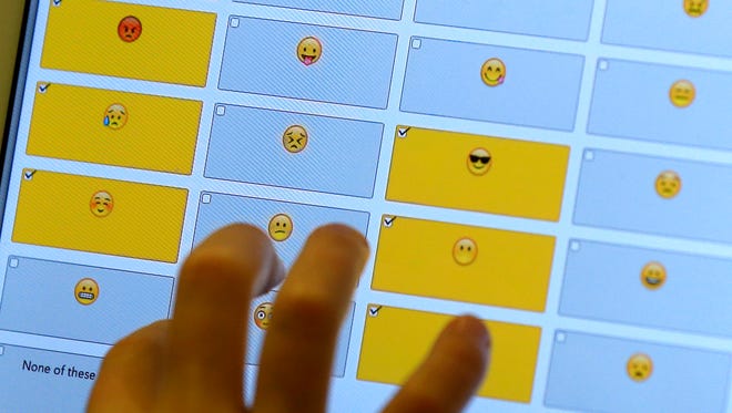 In this Feb. 15, 2016 photo, a student demonstrates how emojis are used during a research session on the Kansas State University campus in Olathe, Kansas.