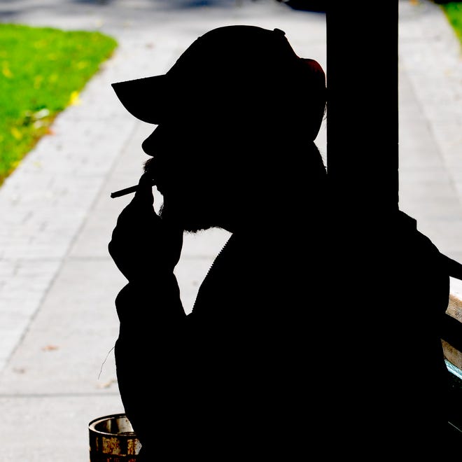 Mason Manor resident Michael VanDenHeuvel smokes a cigarette outside of the housing complex, Wednesday, October 8, 2014. Green Bay public housing units are now smoke-free.