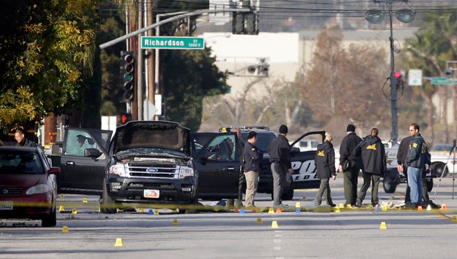 Investigators gather Dec. 3, 2015, around an SUV that was involved in the police shootout with suspects in San Bernardino, Calif.
