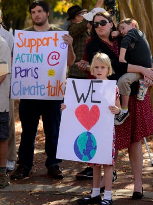 Penelope Emerson,8, holds up a sign Sunday during the Pensacola Climate March which started at Martin Luther King Jr. Memorial Plaza. The Pensacola march takes place on the eve of the biggest U.N. summit in decades as representatives from over 190 nations gather to create an agreement on climate change.