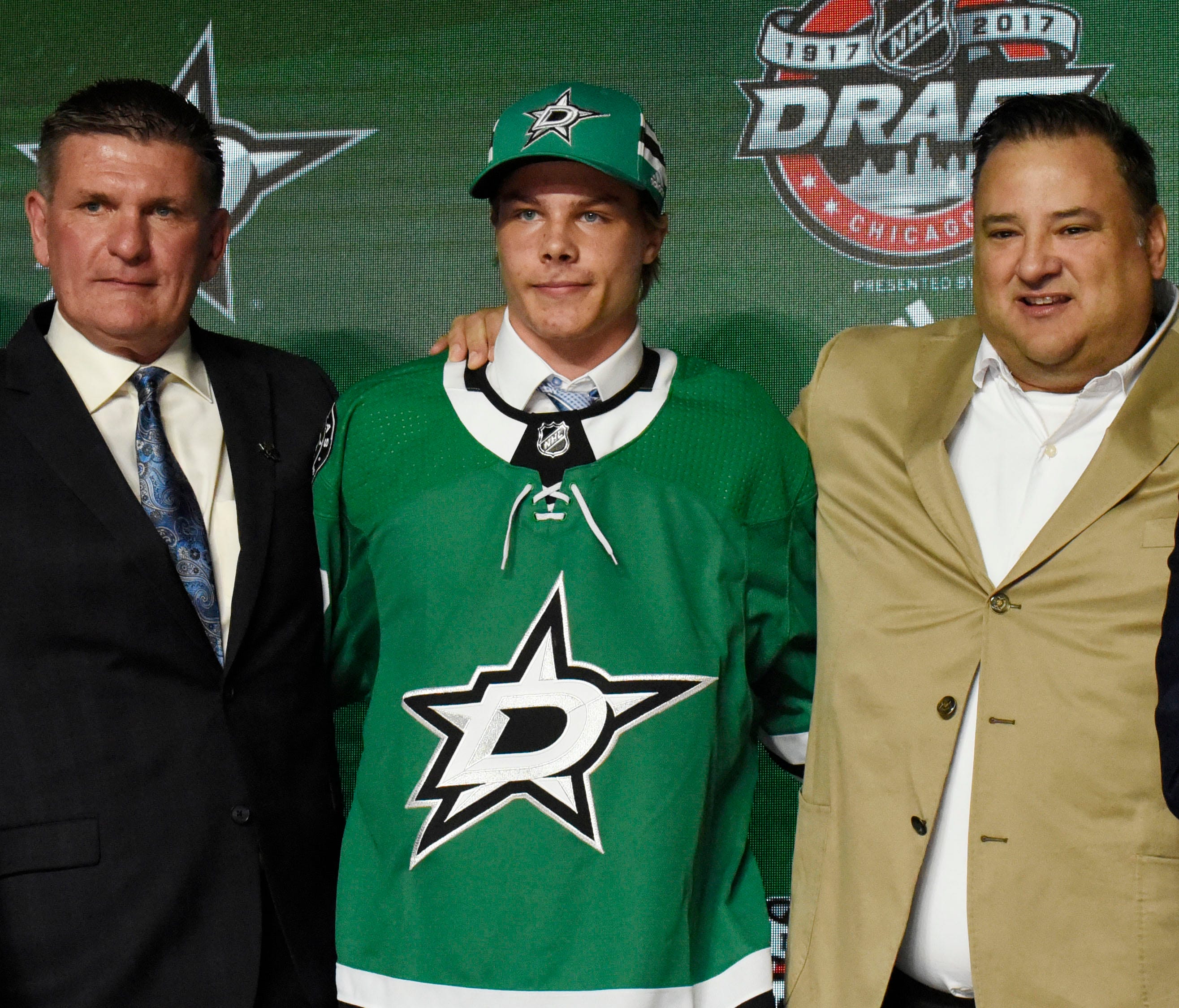 Miro Heiskanen poses for photos after being selected as the number three overall pick to the Dallas Stars in the NHL draft.