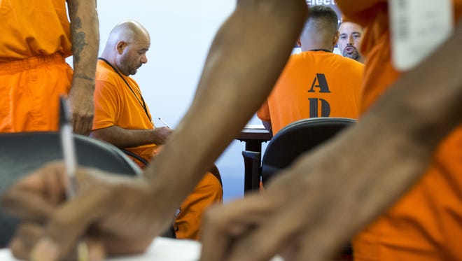 Inmates wait for their turn to meet employers to fill out job applications at the Sunrise Employment Center at Lewis Prison in Buckeye.