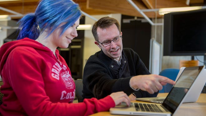 Erik Simpson, professor of English, and Kenzie Doyle, a senior majoring in psychology, confer as they develop a database of digital humanities projects in the Creative Computing Lab in the Forum on the campus of Grinnell College Feb. 23, 2015. Grinnell College and the University of Iowa have received a $1.6 million grant from the Andrew W. Mellon Foundation to develop humanities-centered collaborations that expand the use of digital technology among faculty and students. Professor Simpson is Grinnell's principal investigator and Doyle is a student assistant for the project, which is titled "Digital Bridges for Humanistic Inquiry." (Photo by Justin Hayworth/Grinnell College)