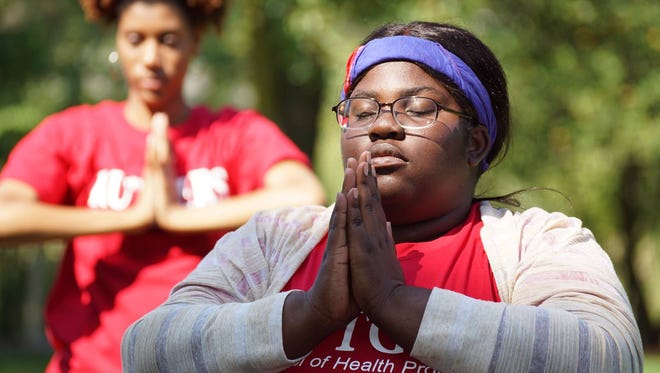 Rutgers University students Esther Charles,(right,  a pre-med/pre-public health major in the School of Environmental and Biological Sciences, and Jennifer Baez, a health information management major in the School of Health Professions, practice yoga at a wellness retreat sponsored by Rutgers School of Health Professions