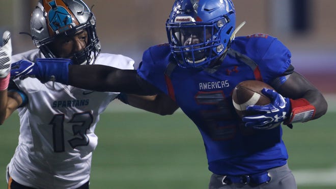 Then-Americas running back Josh Fields, right, fends off a tackle attempt by Pebble Hills defender Jaylien Spires during a football game last year at the SAC.