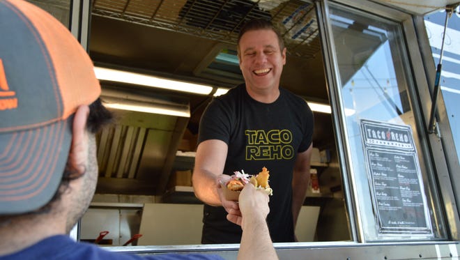 Billy Lucas, chef and owner of Taco Reho, hands off a baja fish taco.