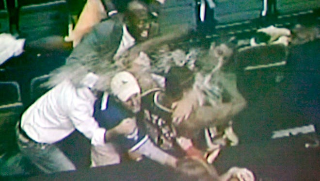 In this video framegrab shown during a news conference, in Pontiac, Mich, Wednesday, Dec. 8, 2004, by Oakland County (Mich). prosecutors, spectator John Green, center with baseball cap , holds Indiana Pacers' Ron Artest during a fight between fans and several Indiana players, at the Palace in Auburn Hills, Mich., Nov. 19, 2004.  Oakland County (Mich.) prosecutor David G. Gorcyca announced Wednesday, that five Pacers players and seven fans were charged Wednesday in one of the worst brawls in U.S. sports history. Artest, Stephen Jackson, David Harrison and Anthony Johnson all were charged with one count of assault and battery, a misdemeanor that carries a maximum penalty of about three months in jail and a fine of up to $500. Jermaine O'Neal, a three-time NBA All-Star, was charged with two counts of assault and battery.Green is one of the seven spectators who were charged in the brawl. (AP Photo/Oakland County Prosecutor)