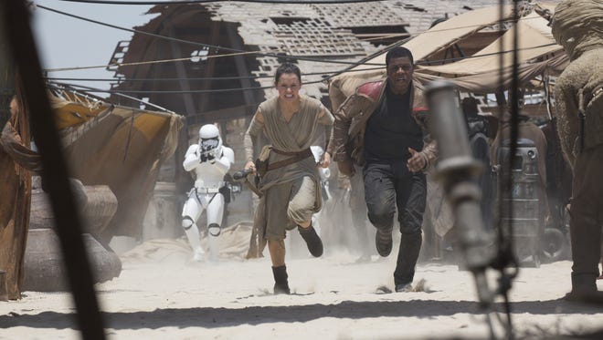 Rey (Daisy Ridley) and Finn (John Boyega) are chased by the First Order in 'Star Wars: The Force Awakens.'