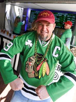 Blackhawks fan Jeff Chlebus of Ankeny flexes his hokey