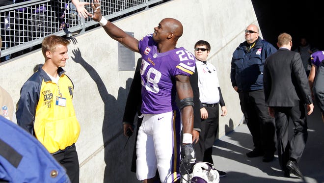 Minnesota Vikings running back Adrian Peterson greets a fan after a game against the Kansas City Chiefs on Sunday, Oct. 18, 2015, in Minneapolis.