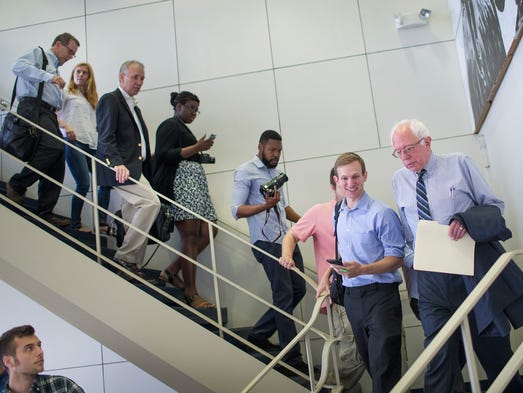 Sanders walks with supporters and reporters during