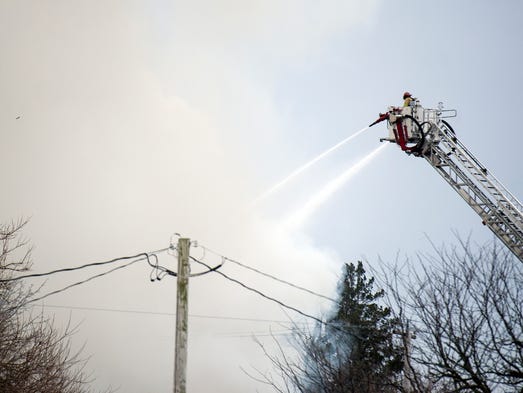 Firefighters work on the scene of a house fire in the