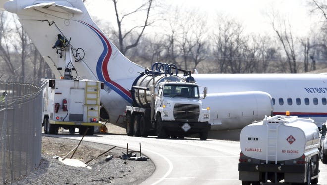 Crews work on a plane that was carrying the Michigan men's basketball team when it slid off a runway March 8, 2017, during an aborted takeoff, causing extensive damage to the aircraft and forcing passengers to exit via emergency slides at Willow Run Airport in Ypsilanti.