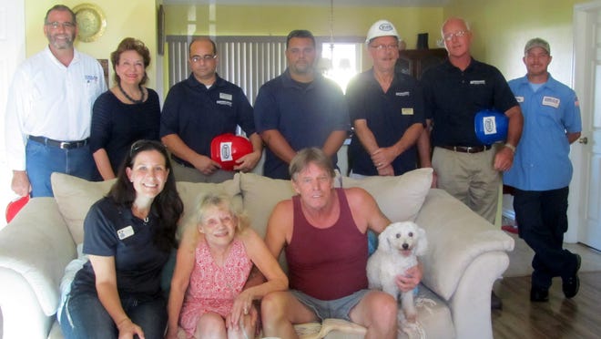 Team members of CoolAir and Ferguson Enterprises along with Christi Pritchett Sarlo of Lee BIA Builders Care pose with the Fagans after they learn of their air conditioning surprise.