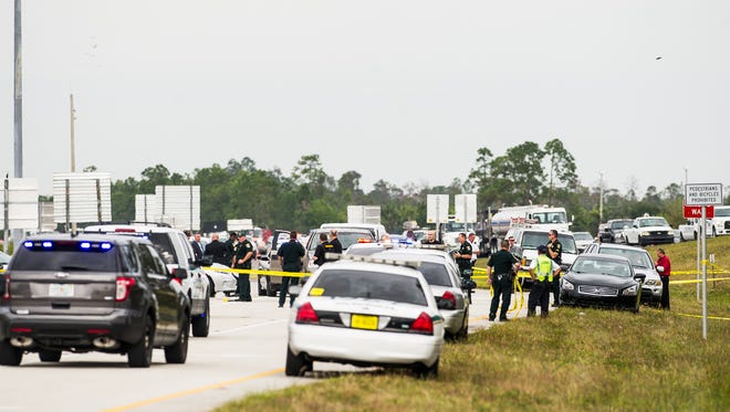 Law enforcement officers and emergency crews line the Interstate 75 off ramp at Corkscrew Road in Estero, Fla., on Monday, Nov. 14, 2016, after an officer-involved shooting.