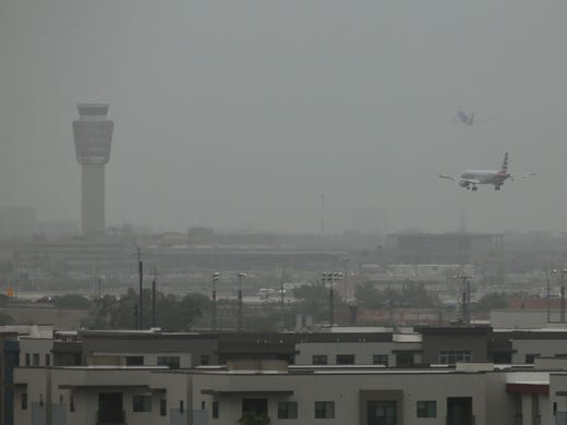 Passenger jets land and take-off in the dust at Sky