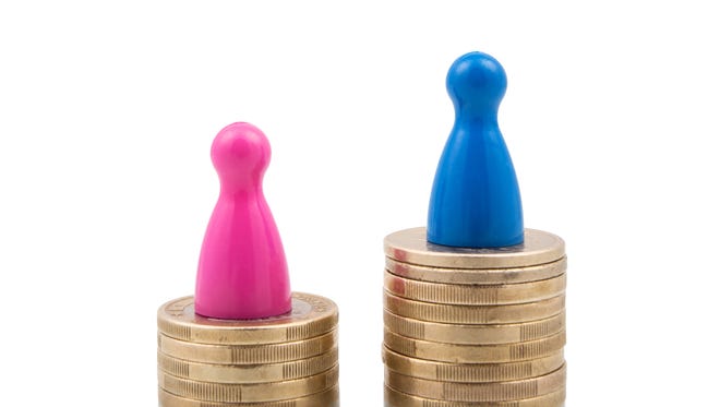 Pink and blue figures on different coin stacks. Concept for gender pay gap.