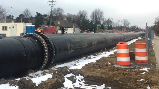 The temporary sewer bypass piping on top of 15 Mile Road near the sewer collapse and sinkhole in Fraser on March 17, 2017.