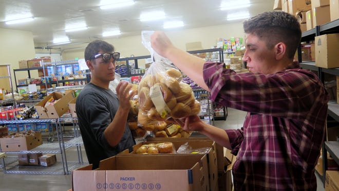 Alex Johns, left, and Sam Peterson, missionaries with The Church of Jesus Christ of Latter-day Saints, were connected through the JustServe program to do volunteer work at the SwitchPoint food pantry in St. George Friday, Sept. 4, 2015.