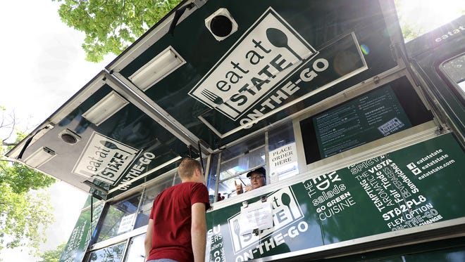 Jason Muffett orders lunch from Jeannie Tucker at the Eat at State On-The-Go Food Truck outside the MSU Auditorium on campus   Thursday 5/30/2013. (Rod Sanford | Lansing State Journal)