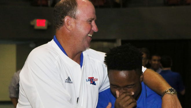 Louisiana Tech football coach Skip Holtz laughs with Bulldogs' running back Boston Scott over something they saw on Scott's cell phone before The Happening at the Monroe Civic Center on Thursday.