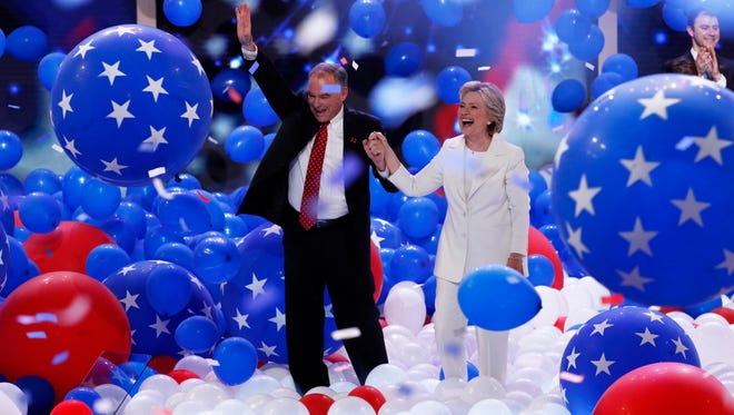 Democratic vice presidential nominee Sen. Tim Kaine, D-Va., and Democratic presidential nominee Hillary Clinton walk through the falling balloons during the final day of the Democratic National Convention in Philadelphia , Thursday, July 28, 2016.
