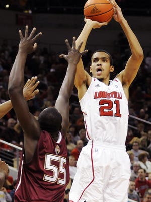 Louisville's Jared Swopshire, right, puts up a shot past the defense of IUPUI's Christian Siakam (55) during the first half of their NCAA college basketball game, Wednesday, Dec. 7, 2011, in Louisville, Ky. (AP Photo/Timothy D. Easley)
