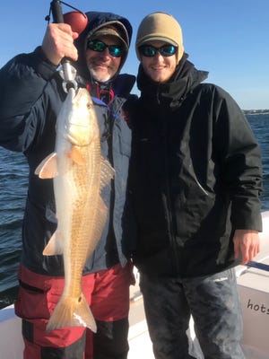 Captain Brad Gundersen and his father Michael Gundersen with a nice redfish he caught this past week in Pensacola Bay.