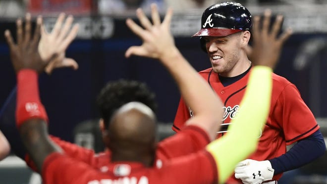 Atlanta Braves' Freddie Freeman crosses home plate to score on a winning two-run home during the 11th inning of a baseball game against the Boston Red Sox, Friday, Sept. 25, 2020, in Atlanta.