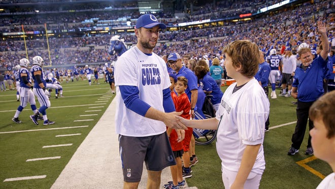 Indianapolis Colts quarterback Andrew Luck (12) greets area peewee football kids before the start of their game at Lucas Oil Stadium Sunday, Sept. 24 2017.