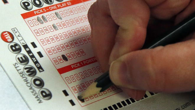 A customer fills out her Powerball lottery ticket at a convenience store in North Andover, Mass., Wednesday, Feb. 19, 2014.