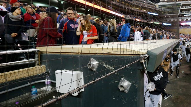 In this Wednesday, April 13, 2016 file photo, Minnesota Twins front row fans have protective netting to look through over the dugouts as they watch baseball games at Target Field where they took in the Twins and Chicago White Sox game in Minneapolis. The Cleveland Indians and Minnesota Twins are the latest Major League Baseball teams to announce plans for expansions of safety netting at their ballparks for the 2018 season. (AP Photo/Jim Mone, File)
