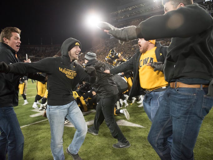 Iowa fans begin to pour out onto the field after the