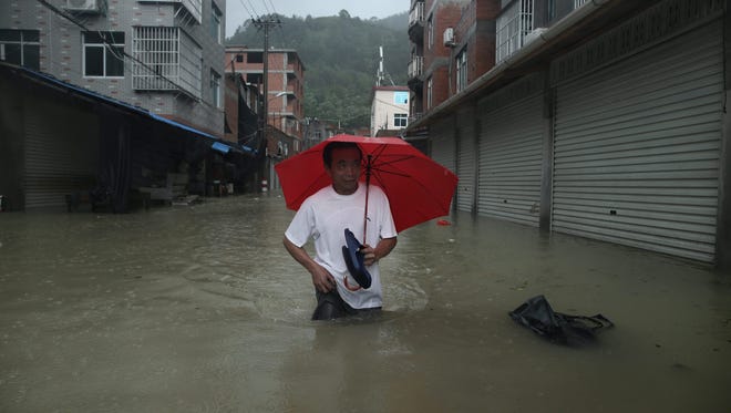 A man walks in the flooded Chengli village in Ningde, south-east China's Fujian province, August 9, 2015.