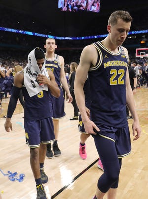 Michigan's Zavier Simpson, left, and Duncan Robinson leave the floor after losing, 79-62, in the national championship game to Villanova at the Alamodome in San Antonio.