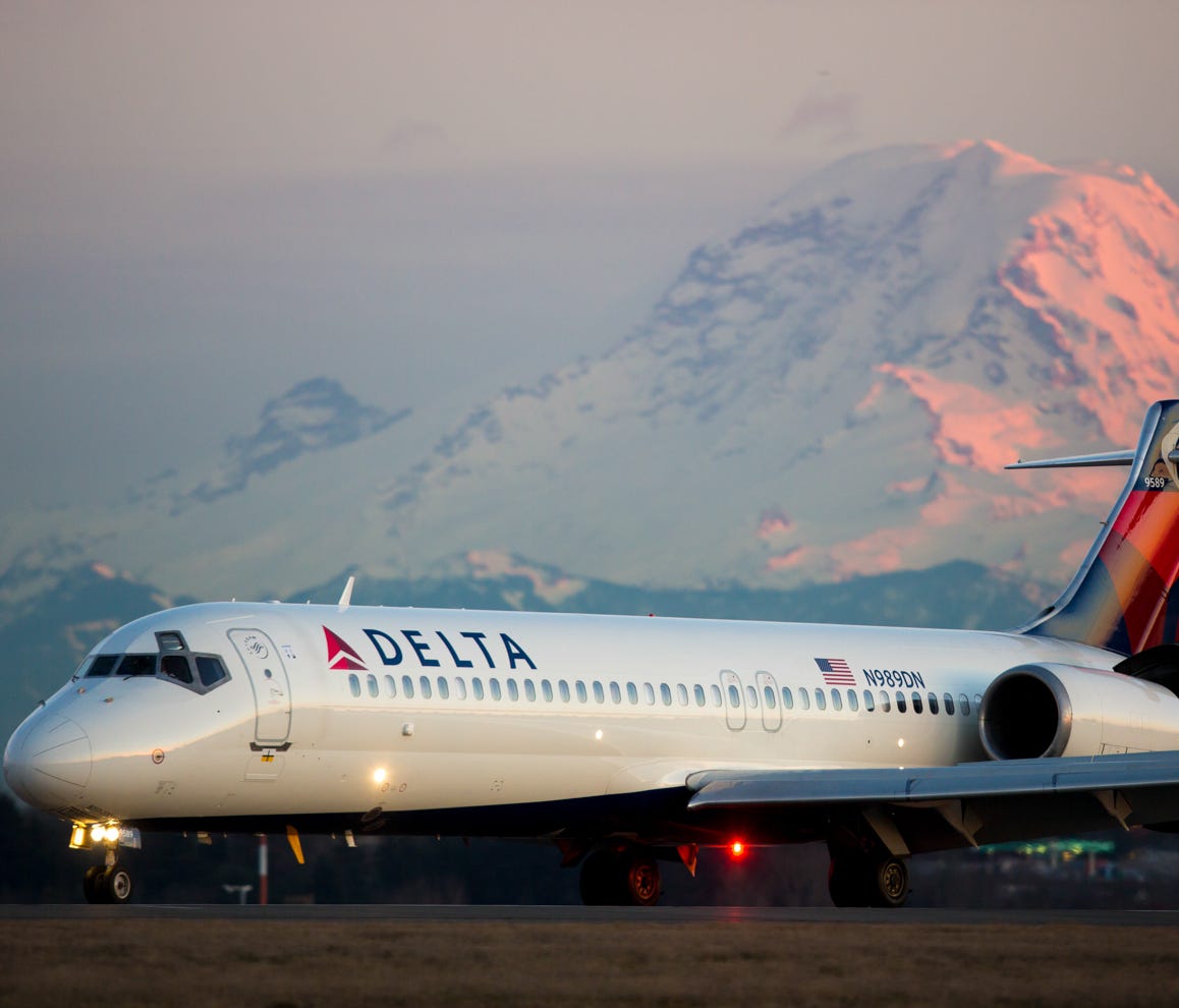 Mt. Rainier looms in the background as a Delta Air Lines Boeing 717 lands at Seattle-Tacoma International Airport in February 2017.