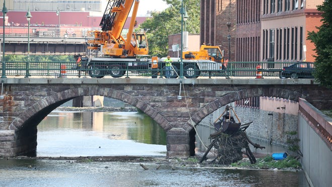 The Andrews Street Bridge was closed from St. Paul Street to State Street in downtown Rochester as City Department of Environmental Services crews cleaned debris from the Genesee River Saturday, June 30, 2018. 