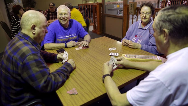 Steve Jansen, Tom Koss, JoAnn Goettel and Bruce Hillegas laugh as they play a game of cribbage in December at the Thompson Community Center in Appleton.
