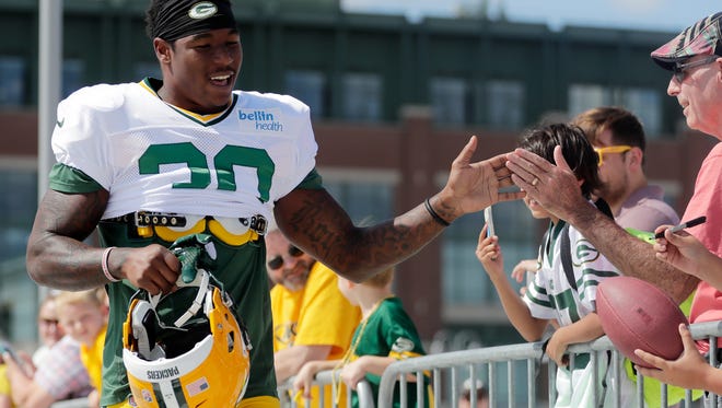 Green Bay Packers running back Jamaal Williams (30) high fives fans on his way to training camp practice on Tuesday, Aug. 22, 2017 at Ray Nitschke Field.