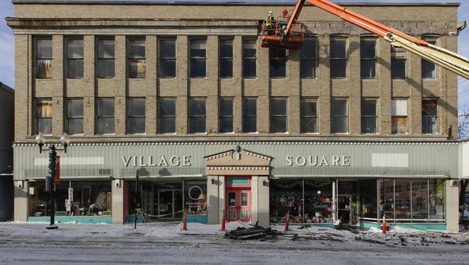 Crews work to repair the damage to the Village Square building Thursday in Manitowoc. High winds and heavy snowfall brought down parts of the building.