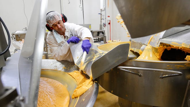 Mix room operator Dan Steeno finishes the mixing process of the Pine River cheese spread Friday, Nov. 17, 2017, in Newton, Wisconsin.