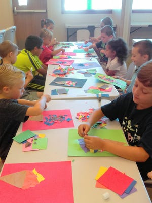 On the first day of Summer Camp, children learn about the five senses. Here they learn about “touch” by ripping up paper to create an ice cream cone.