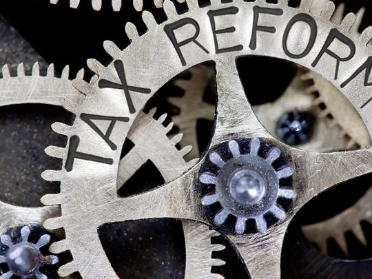 Clockwork gears in metal, with the words "Tax Reform" engraved on the side.