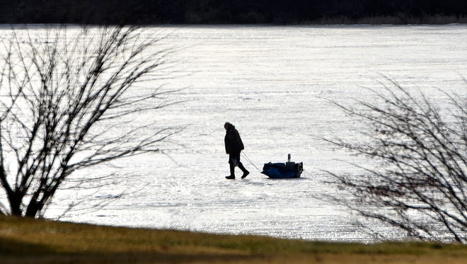 An ice fisherman moves his portable shelter to a different spot on Big Fish Lake Monday afternoon. For more on this season's ice fishing review, turn to page 3. 