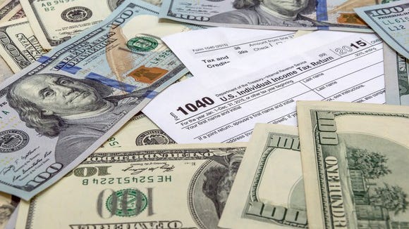 U.S. tax forms with money scattered on top.